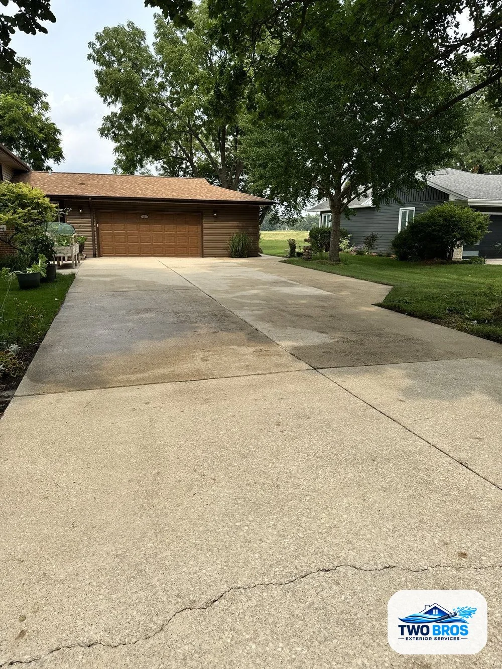 Driveway after pressure washing, bright and free of dirt and tire marks